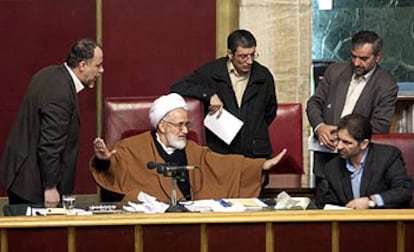 El presidente del Parlamento iraní, en el centro, trata de calmar las protestas de los diputados reformistas.