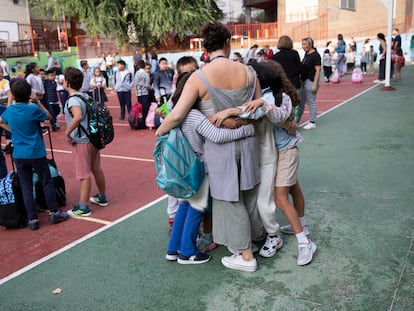 Una maestra se abraza a sus alumnas en el patio del colegio público Dionisio Ridruejo de Madrid, este miércoles.