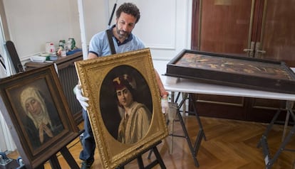 Un técnico sostiene la obra de Winterhalter. Y a la izquierda, una Virgen de Escuela Valenciana del siglo XV.