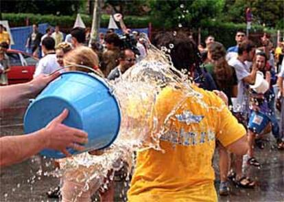 Participantes en la Batalla Naval se lanzan cubos de agua durante la celebración del tradicional festejo en Vallecas.