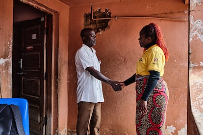 Eugenio Paulo Sumbane tiene 71 años y es un minero mozambiqueño que ha sobrevivido a dos tuberculosis. Maria Sitoe es activista comunitaria de AMIMO (Asociación de Mineros de Mozambique), que apoya a mineros y exmineros que pasaron por la tuberculosis. Ambos se dan la mano en la puerta de la casa de Paulo.