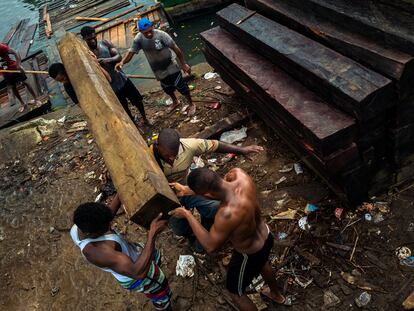 Trabajadores afrocolombianos cargan madera aserrada para ser exportada, en Turbo (Colombia), el 3 de diciembre de 2019.