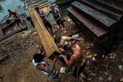 Trabajadores afrocolombianos cargan madera aserrada para ser exportada, en Turbo, Colombia