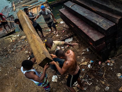 Trabajadores afrocolombianos cargan madera aserrada para ser exportada, en Turbo (Colombia), el 3 de diciembre de 2019.