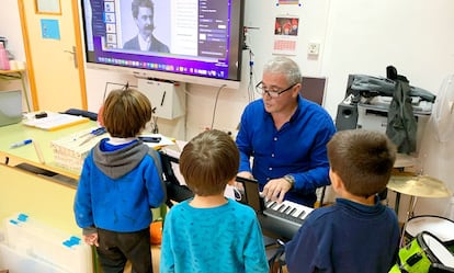 Un profesor enseña a unos niños nociones de música, como parte del proyecto educacional de la Fundación Atrio Cáceres.