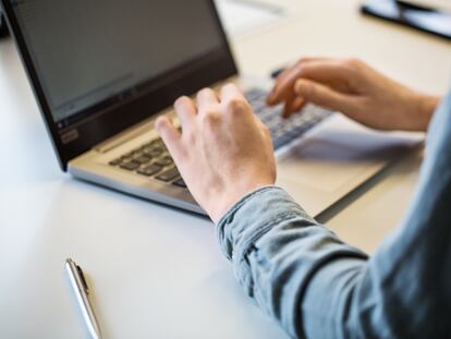 Una mujer utiliza un ordenador portátil.