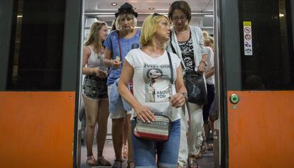 Unos turistas bajan del tren en la estaci&oacute;n de plaza Catalu&ntilde;a.