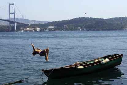 Un niño salta desde un bote en el mar de Bosporous, en Istambul (Turquia).