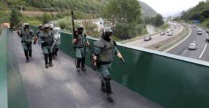 Efectivos de la Guardia Civil tras la reapertura al trafico de la A66 en Ujo, donde fue colocada ayer una barricada y se produjeron enfrentamientos entre manifestantes y las fuerzas y cuerpos de seguridad, en el marco de las protestas mineras contra los recortes previstos en el sector del carbón.