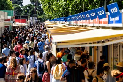 Visitantes asisten a la Feria del Libro, esta calurosa mañana en el parque de El Retiro.