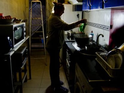 Una mujer en la cocina de su vivienda afectada por los cortes de luz y agua.