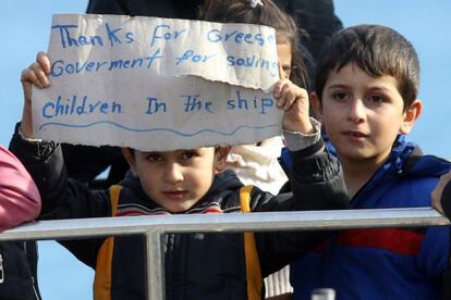 "Gracias al Gobierno griego por salvar a niños en el barco", reza el cartel que exhibe uno de los menores rescatados a su llegada a puerto.