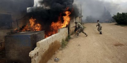 Soldados del Ej&eacute;rcito sirio entran en una casa en Dumaina, al oeste, este lunes. 