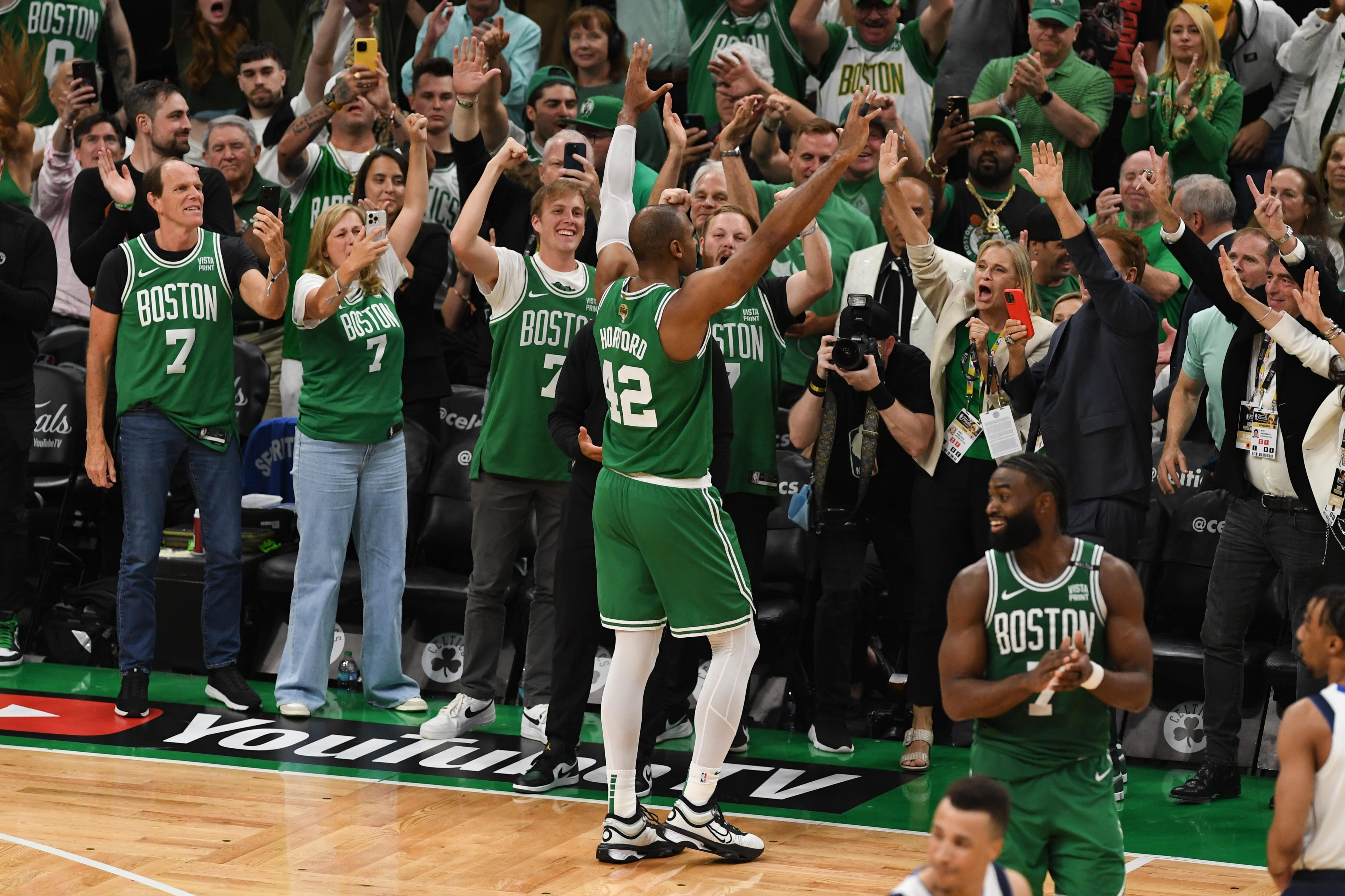 Al Horford (en el centro), pívot de los Boston Celtics, saluda a los aficionados tras dirigirse al banquillo en los minutos finales del partido.