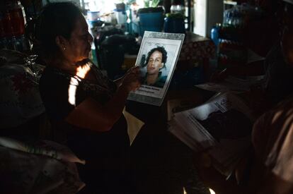 Una vecina de localidad de Puerto Madero examina las fotos de los desaparecidos durante la visita de la Caravana de madres Migrantes centroamericanas por tierras del Soconusco chiapaneco, en Puerto Madero (Chiapas).