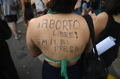 Una manifestante a favor del aborto acude a una marcha con un mensaje en contra del presidente argentino escrito en su espalda, el 8 de marzo de 2024.