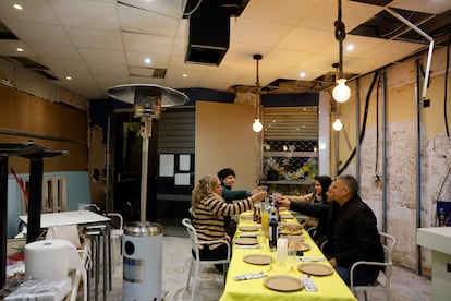 Una familia cena en Nochevieja en un restaurante afectado por la dana en Paiporta.