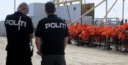 Dos polic&iacute;as, frente a un barco de Frontex que patrulla el Mediterr&aacute;neo central.