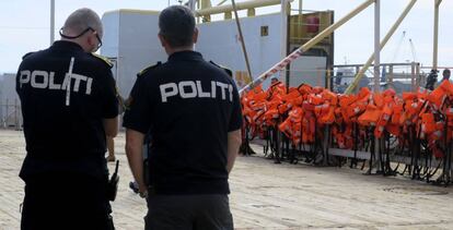 Dos policías, frente a un barco de Frontex que patrulla el Mediterráneo central.