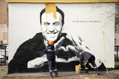 Trabajadores municipales tapan un mural con el retrato del activista y el lema "Héroe de nuestro tiempo", que apareció el jueves en la pared de un edificio de San Petersburgo. 