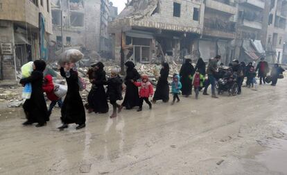 Civiles y niños sirios abandonan un barrio de Alepo de Bustan al-Qasr en dirección al de Fardos, el 13 de diciembre.