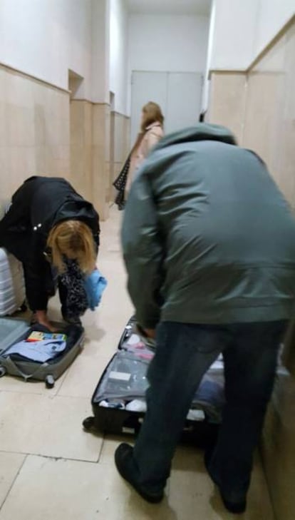 Tourists open their suitcases in the entrance hall.