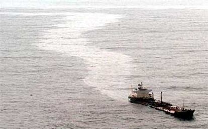 El petrolero <b></b><i>Prestige</i> deja una estela de fuel en su travesía junto a las costas gallegas.