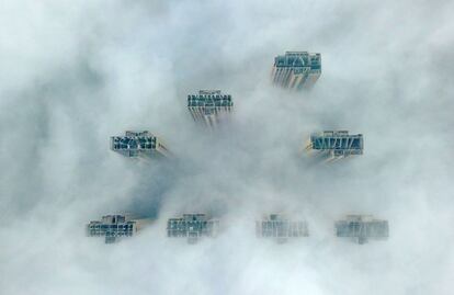 Vista aérea de varios edificios de gran altura que sobresalen de la densa niebla en Yangzhou, en la provincia oriental china de Jiangsu.
