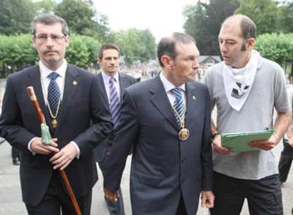 Ibarretxe, con Olano a su derecha, escucha ayer las explicaciones de un miembro de Etxerat a la entrada de la basílica de Loyola.