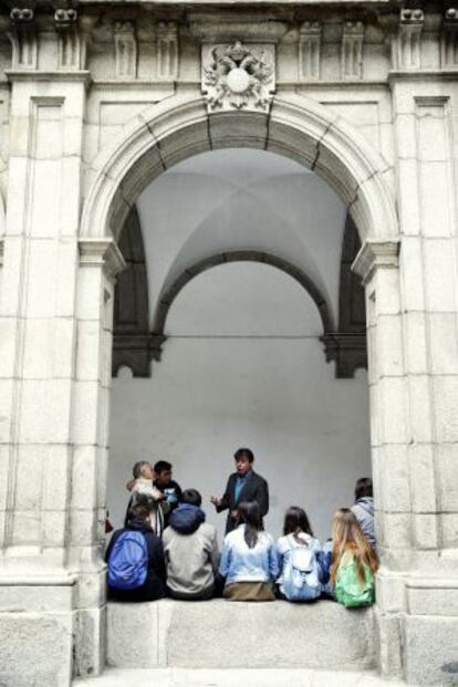 Un profesor charla con los alumnos en el patio del colegio. 