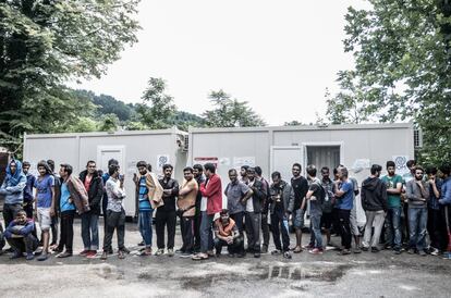 Migrantes y refugiados hacen cola para recoger la comida que distribuye la Cruz Roja bosnia en el inmueble de Bihac.