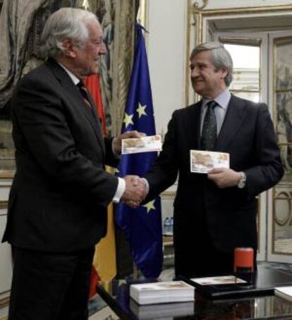 El Alto Comisionado del Gobierno para la Marca España, Carlos Espinosa de los Monteros (i), y el presidente de Correos, Javier Cuesta Nuin (d), durante la presentación del primer sello de la nueva serie filatélica "Marca España".