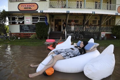 Varios niños juegan con colchonetas en el agua que inunda las calles de ka localidad de Rockhamton, en Queensland (Australia). Las inundaciones ocasionadas por el ciclón Debbie han causado daños en varias regiones del país.