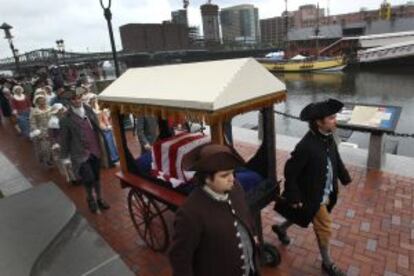 Cubierta por una bandera, una de las dos cajas originales que se conservan del histórico cargamento del Motín del té, durante un desfile conmemorativo en Boston.
