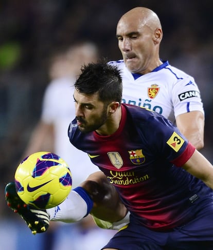 David Villa pelea el balón con Movilla.