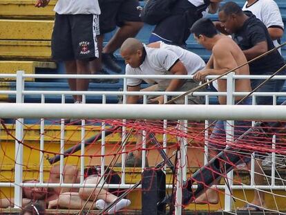 Un hincha golpea a otro en el suelo durante los incidentes. 