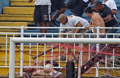 Un hincha golpea a otro en el suelo durante los incidentes. 