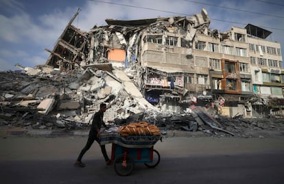 Un hombre anda frente a los edificios destruidos de Gaza tras ser bombardeados en la ofensiva israelí, este jueves. 