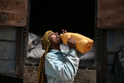 Un trabajador bebía agua el jueves mientras cargaba un tren con sacos de trigo en una estación de Khanna, India. 