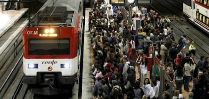 Numerosos viajeros esperan esta mañana en un andén de la estación de Atocha para subir a un tren de cercanías en la jornada de huelga general.