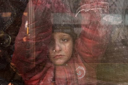 Un niño mira a través de la ventana de un autobús, durante la evacuación del Alepo oriental, en Siria.