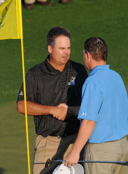 Los golfistas estadounidenses Kenny Perry (izda) y Chad Campbell se saludan tras competir en la tercera ronda del Master de Augusta.