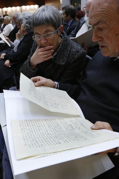 Dos de las personas observan con atención los documentos.