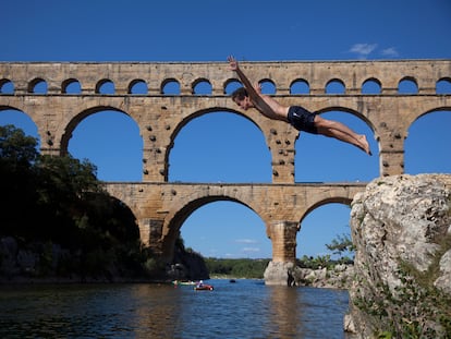 Un adolescente se zambulle en el río en Pont du Gard (Francia).