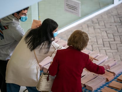 Varios votantes eligen las papeletas en un centro cultural en Mirasierra de Madrid.