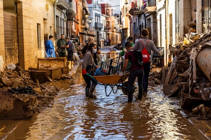 Voluntarios realizan labores de limpieza en la localidad de Paiporta, en Valencia, este lunes, dos semanas después de la dana.