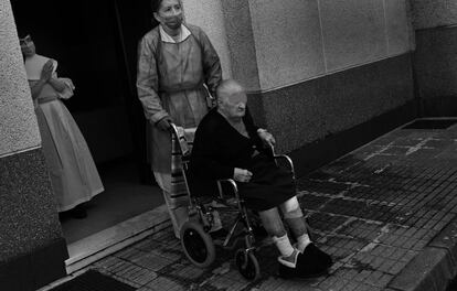 Una religiosa y una trabajadora de la residencia de ancianos Las Hermanitas de Pola de Siero esperan la llegada de la ambulancia para su traslado a un hospital, en La Fresneda, en Siero.