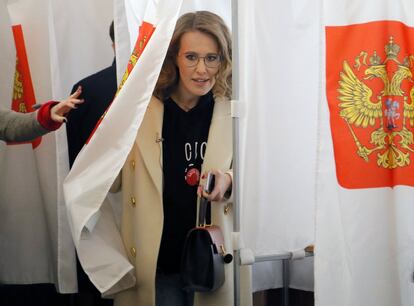 La periodista y candidata presidencial, Ksenia Sobchak, abandona una cabina electoral antes de ejercer su vota en un centro electoral de Moscú.