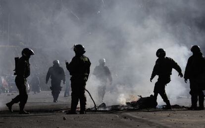 Polic&iacute;as apagan un fuego durante las protestas formadas en La Paz.