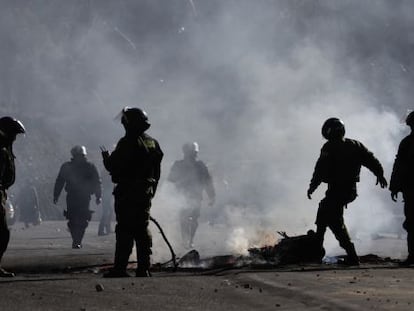 Policías apagan un fuego durante las protestas formadas en La Paz.
